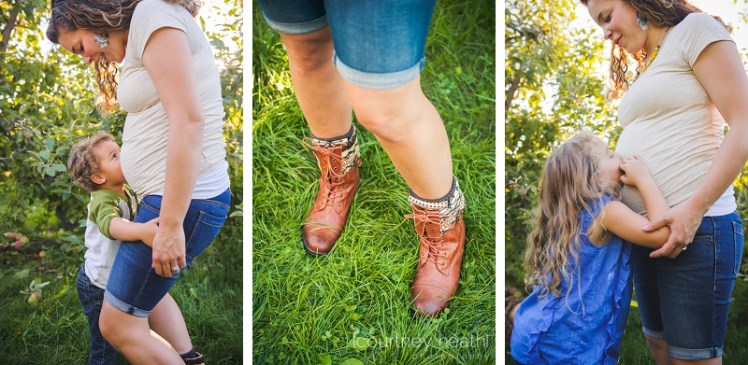 Pregnant woman in apple orchard wearing boots, children kissing belly