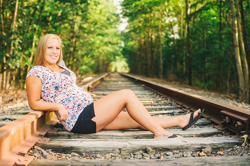 Pregnant mother sitting on railroad tracks