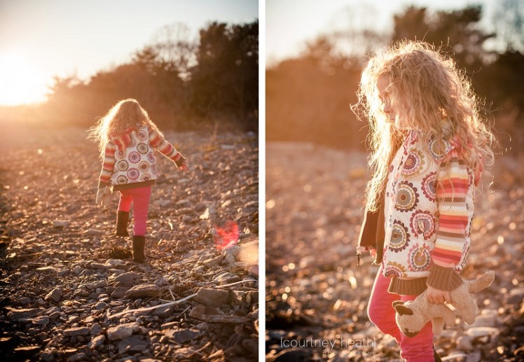 Long curly haired girl at the beach at sunset with lens flare