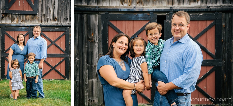 family in front of red barn door