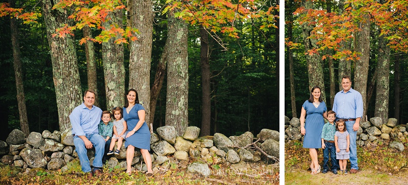 family posing near stone wall and fall foliage